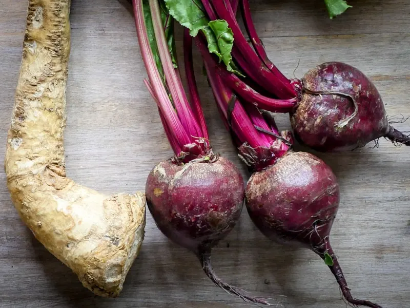 Fresh beets and horseradish on a wooden table