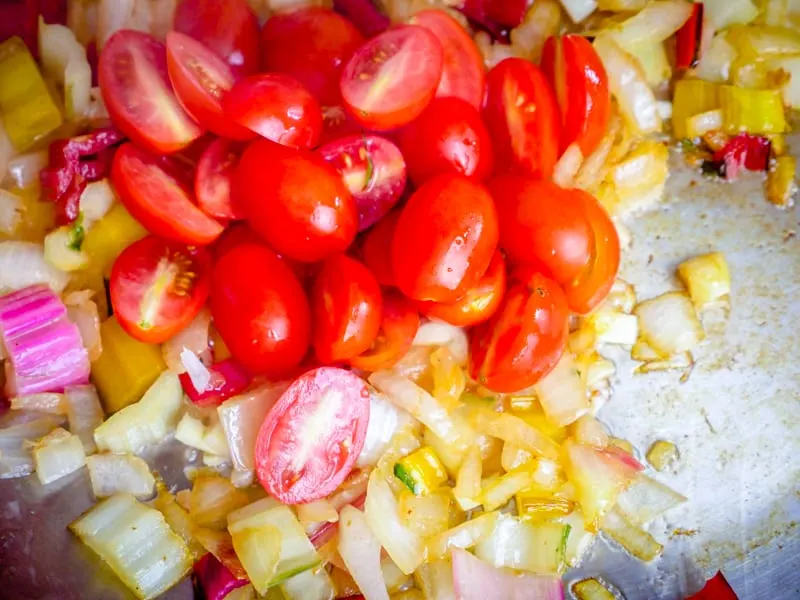 Close up of cherry tomatoes and garlic in a pan