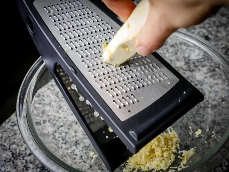 Grating horseradish on a box grater