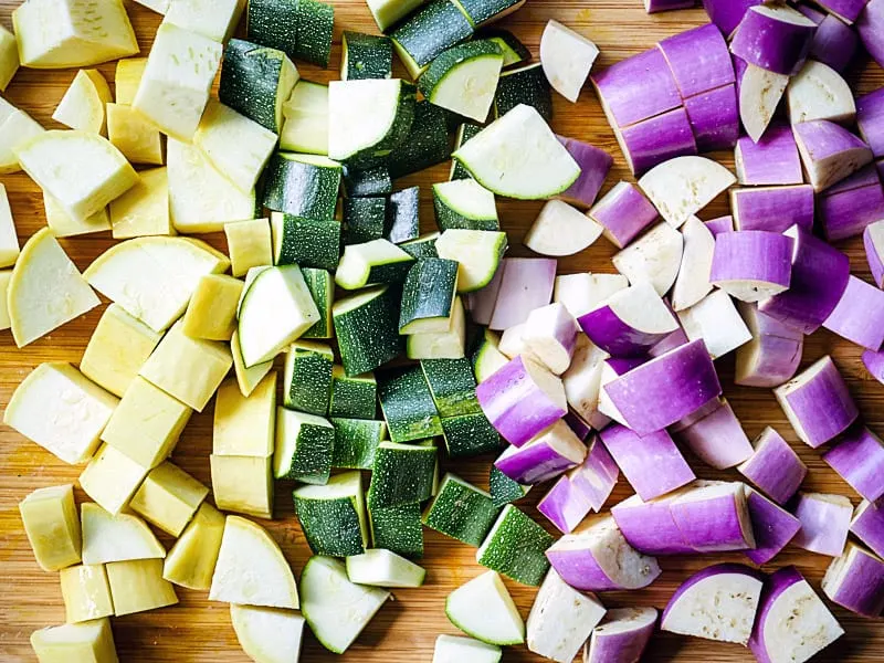 Diced squash and eggplant on a wooden cutting board 