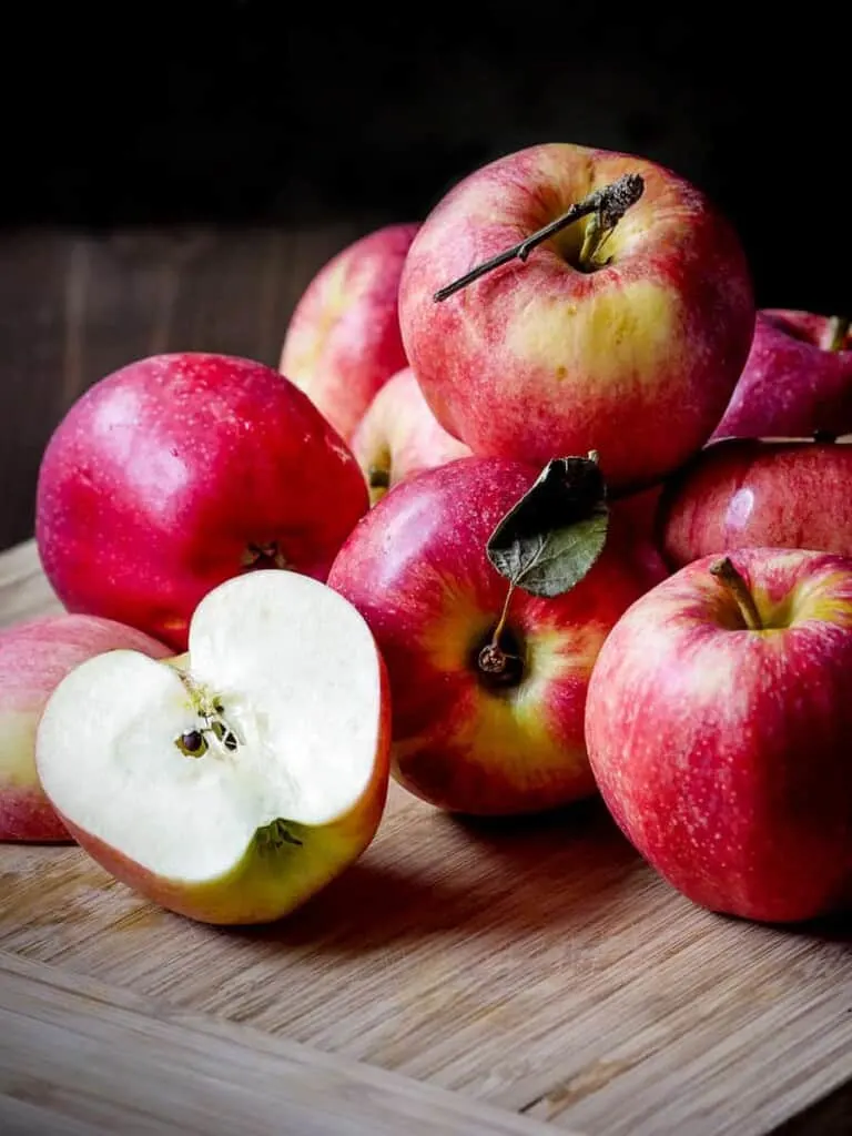 Shot of a pile of apples on a wooden table.