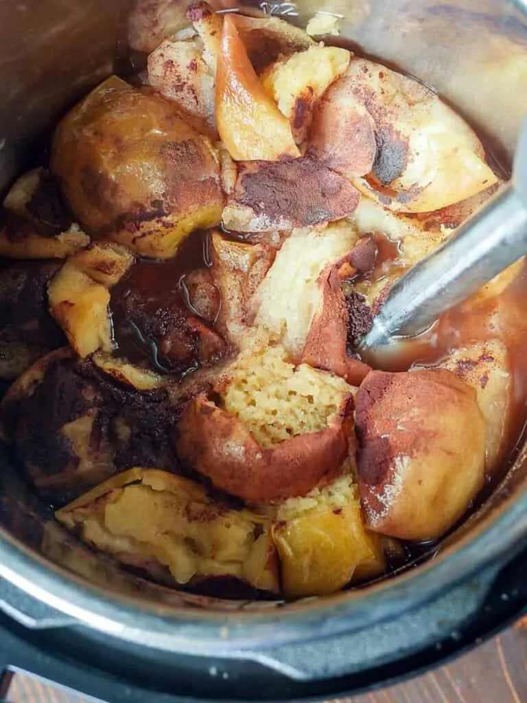 Overhead shot of pureeing apples in an Instant Pot with an immersion blender.