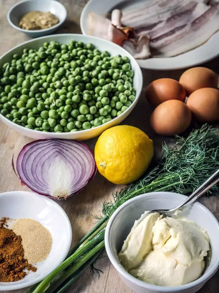 Image of English Pea Salad ingredients on a wooden table.